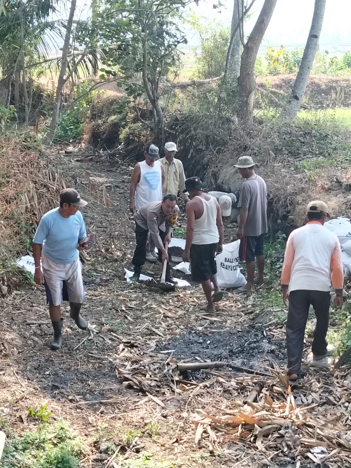 Antisipasi Luapan Air, Bhabinkamtibmas Polsek Kebasen Ikut Kerja Bakti Perbaiki Tanggul Sungai